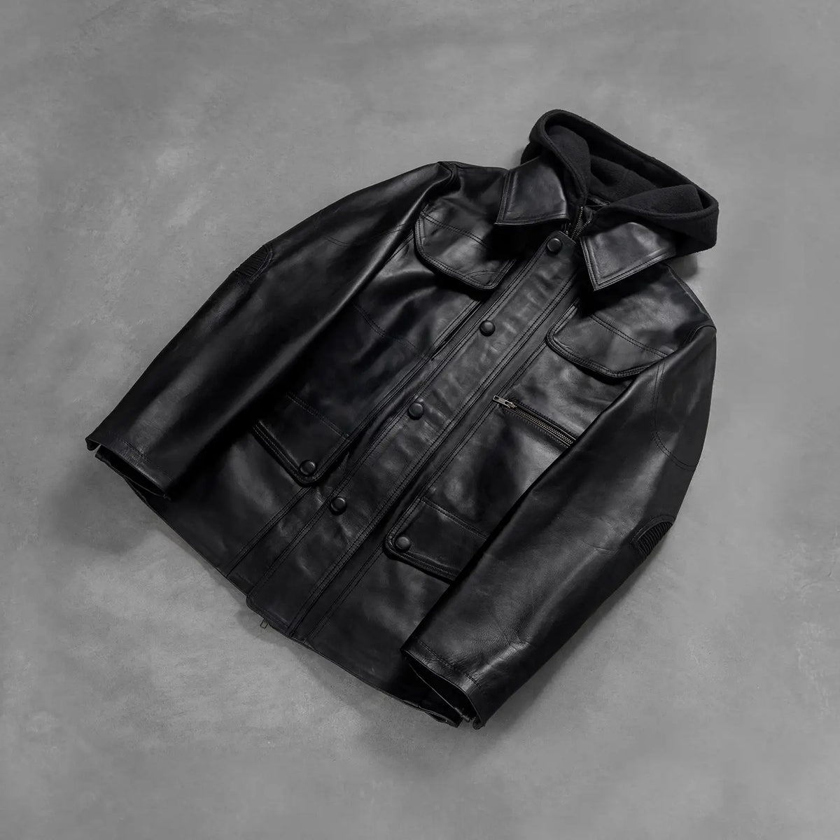 Styled Fit Perspective of Men's Moulder Hooded Negro Chaqueta de Cuero para Hombre on Model - Natural Daylight Drape